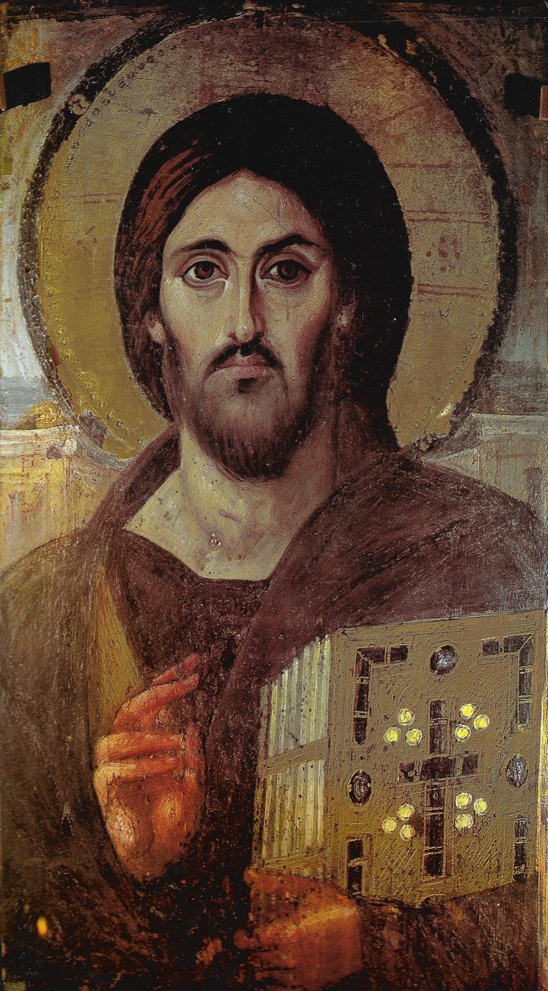 Ancient encaustic icon of Christ, bearded and facing forward, raising his right hand in blessing and holding a jewelled book of the Gospels in his left arm.